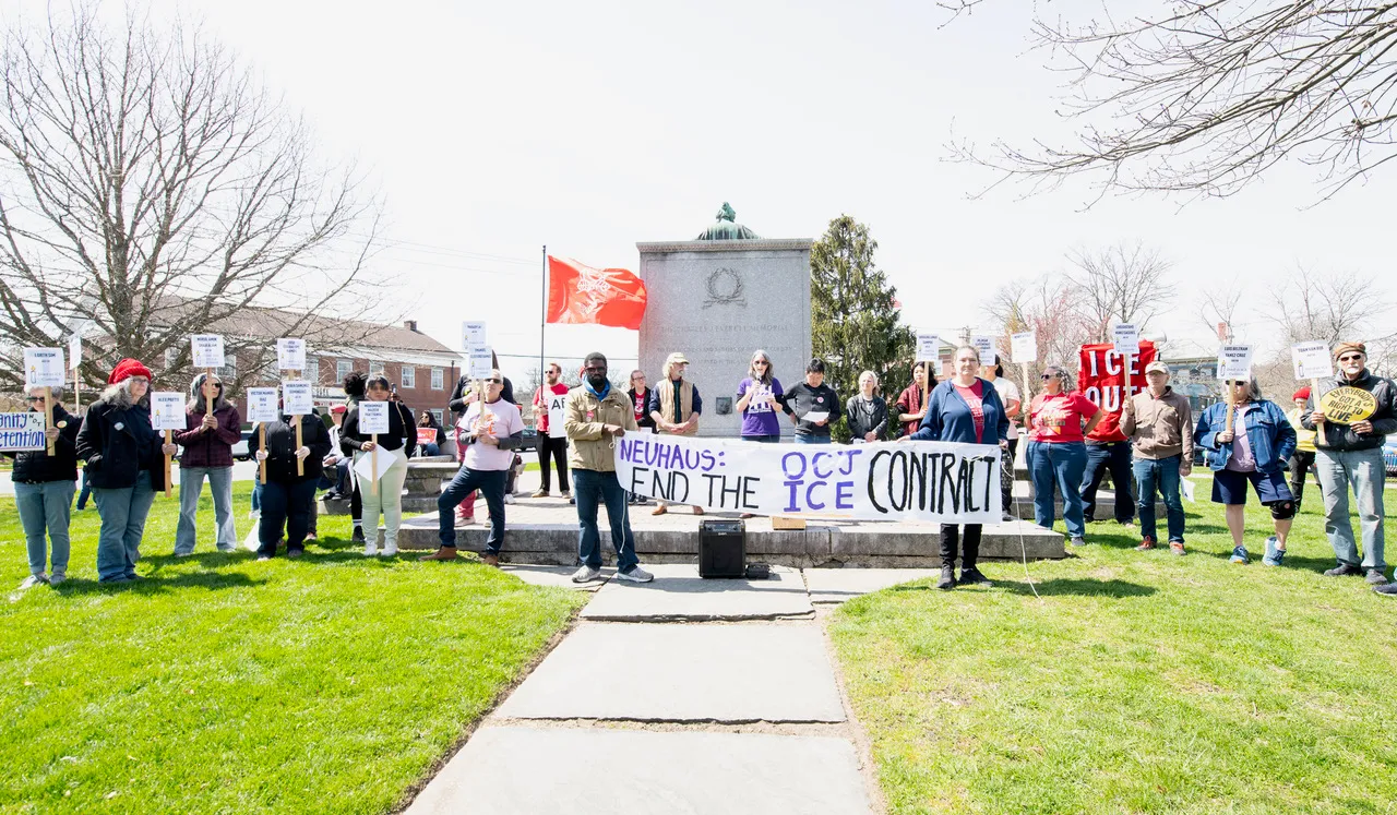 Protesters in Goshen hold a banner reading 'Neuhaus: End the OCJ ICE Contract'
