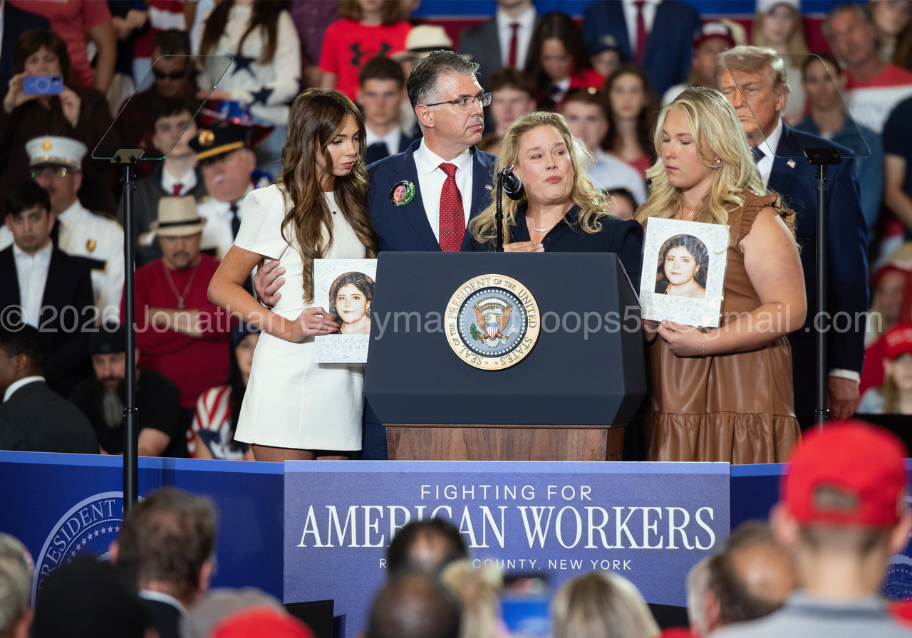 A grieving family speaking at a presidential podium with Donald Trump standing behind them at a rally in Rockland County, New York