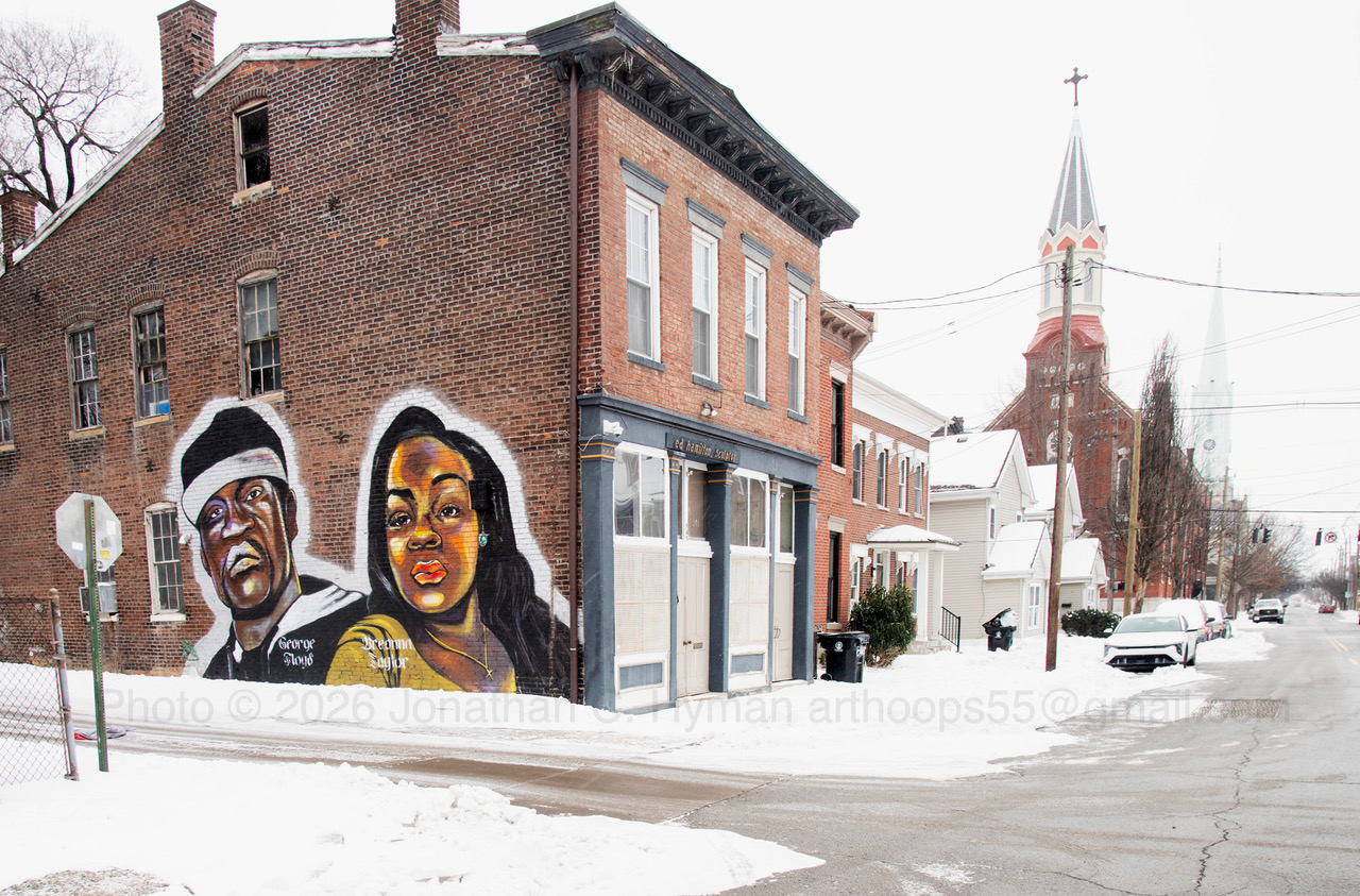 Portrait mural of George Floyd and Breonna Taylor painted on a snowy brick corner building in Louisville